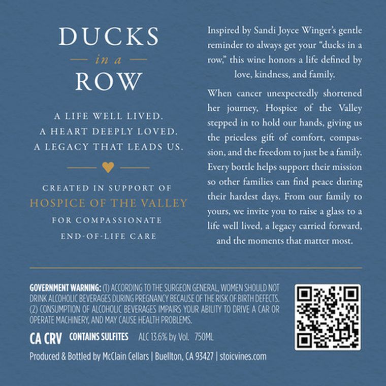 The Ducks in a Row back label in deep lake blue, carrying the dedication to Sandi Joyce Winger